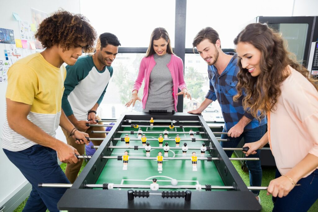 Happy executives playing table football