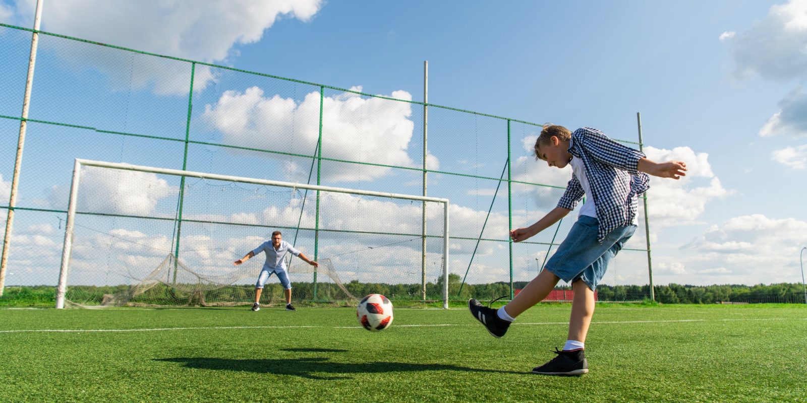 Boy playing soccer in the summer field