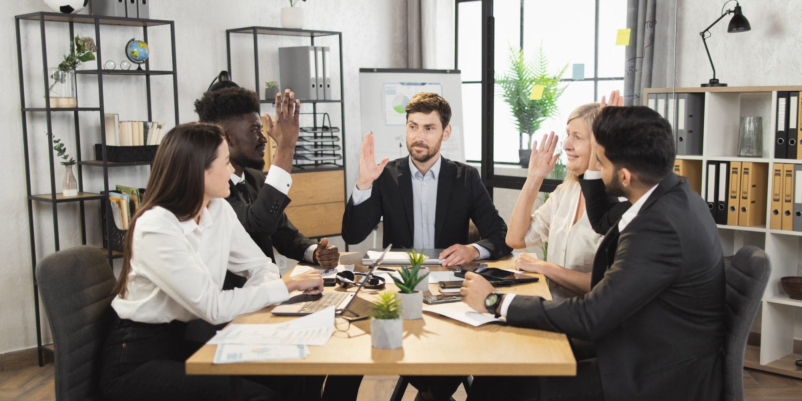 Partners raising hands while supporting business agreement