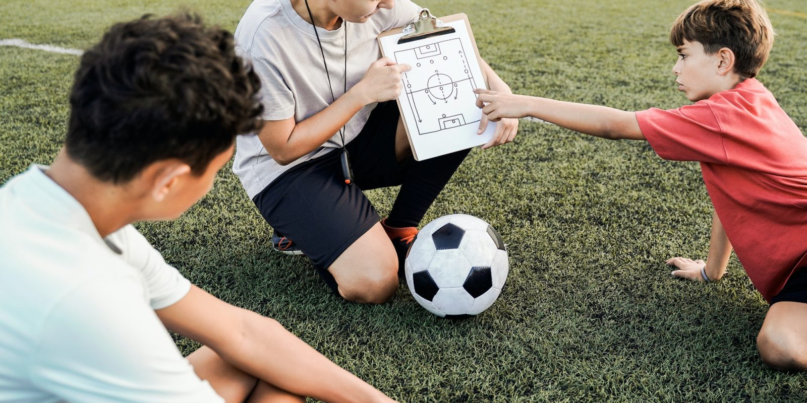 School children with coach teacher during sport training at soccer field - Fitness and educati